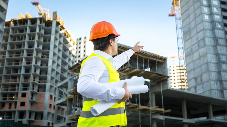 engineer pointing to the ongoing construction of buildings