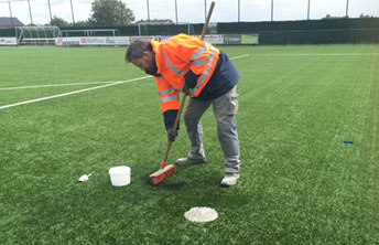 Verzamelen SBR rubber op kunstgras voetbalveld