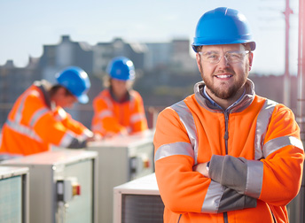 Lachende installateur op het dak bij airco-installaties